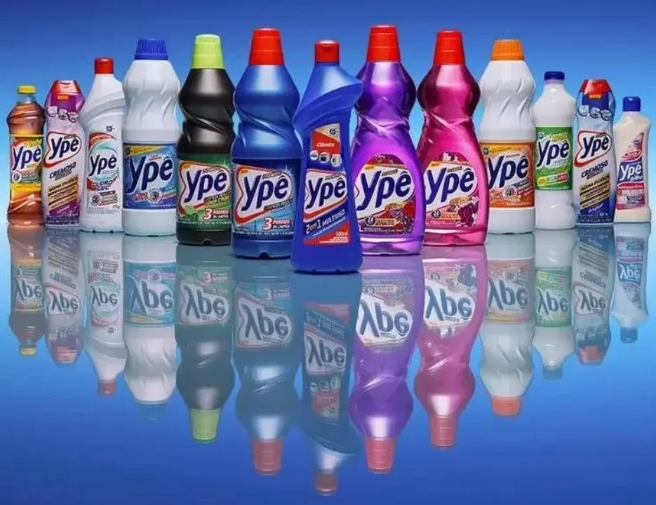 Fileira de produtos de limpeza da marca Ypê, incluindo detergentes e desinfetantes, em fundo branco.