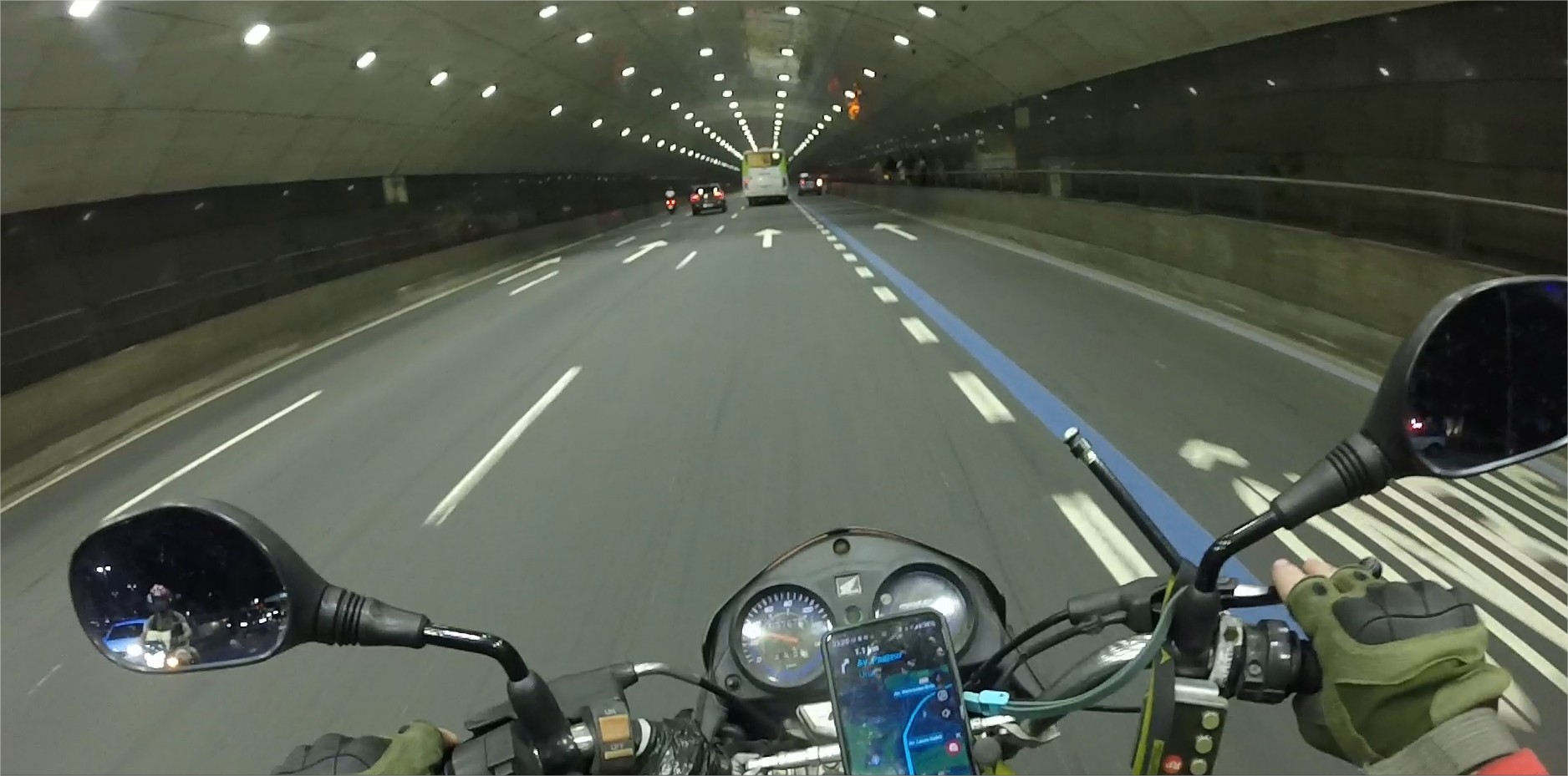 Jornalista e entregador Marcelo Berlinski pilotando moto em túnel no Rio de Janeiro durante a noite.